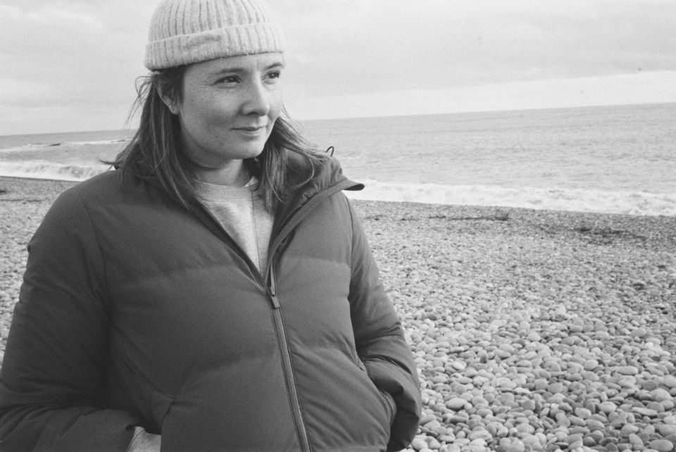 Sarah Elizabeth Drummond on a pebble beach, black and white