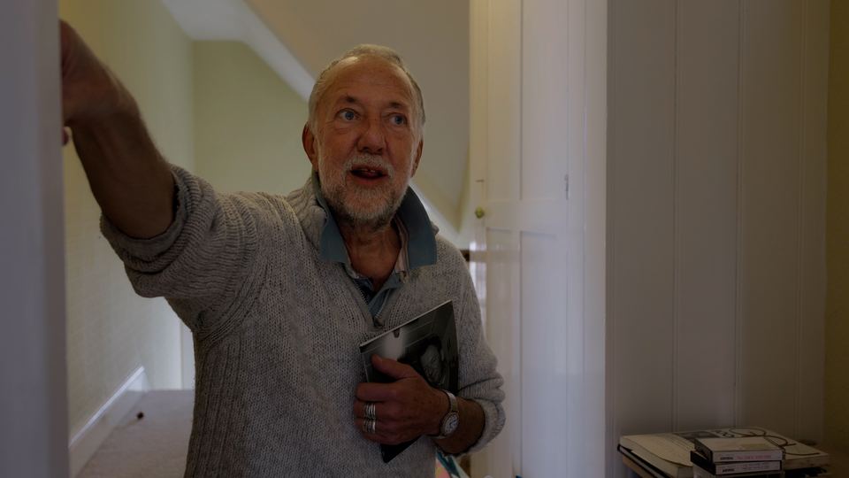 Austin Allen gesturing in his hallway