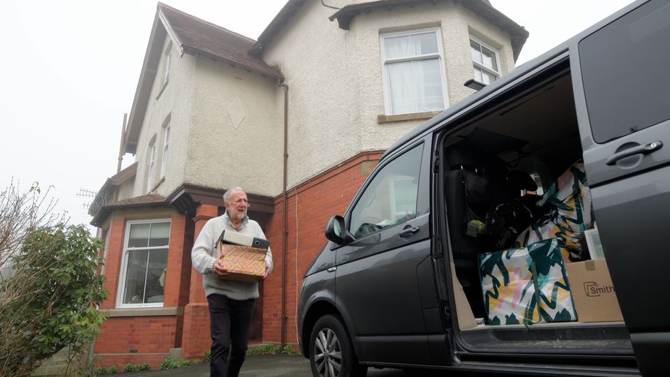 Austin Allen carrying a box from his house to a van